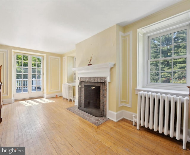 2314 Valley Rd, Huntingdon Valley, PA 19006 - unfurnished living room with french doors, radiator, a fireplace, and hardwood / wood-style flooring