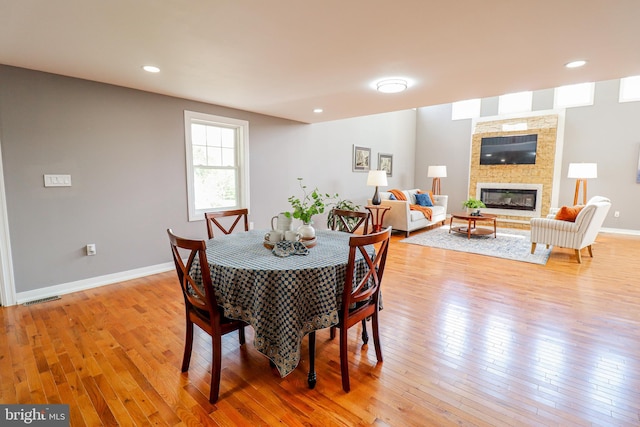 1111 S Mountain Rd, Dillsburg, PA 17019 - dining room with light wood-type flooring, a glass covered fireplace, and baseboards