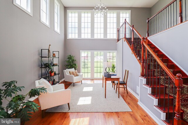 1111 S Mountain Rd, Dillsburg, PA 17019 - living room featuring wood finished floors, stairway, a chandelier, plenty of natural light, and a high ceiling