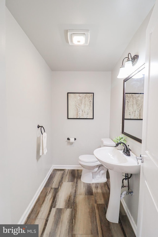 1111 S Mountain Rd, Dillsburg, PA 17019 - half bathroom featuring wood finished floors, toilet, and baseboards