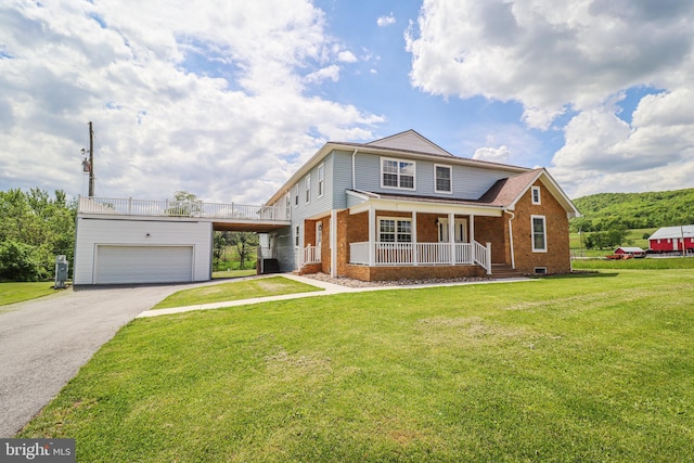 1111 S Mountain Rd, Dillsburg, PA 17019 - view of front facade with asphalt driveway, a porch, brick siding, a front yard, and a garage