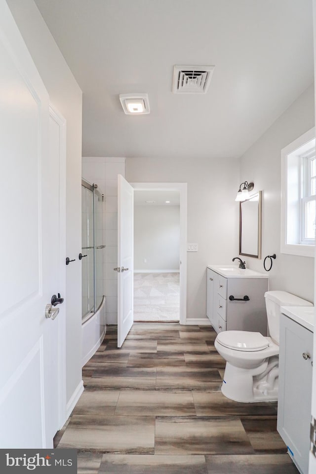 1111 S Mountain Rd, Dillsburg, PA 17019 - full bathroom with vanity, shower / bath combination with glass door, toilet, and wood finished floors