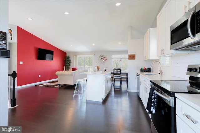 617 Castlewood Dr, Upper Marlboro, MD 20774 - kitchen featuring vaulted ceiling, a sink, white cabinets, baseboards, and appliances with stainless steel finishes