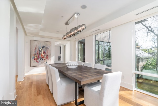 dining area with a healthy amount of sunlight, light wood finished floors, and baseboards