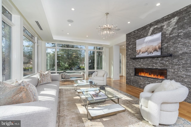 living room with visible vents, an inviting chandelier, a fireplace, recessed lighting, and wood finished floors