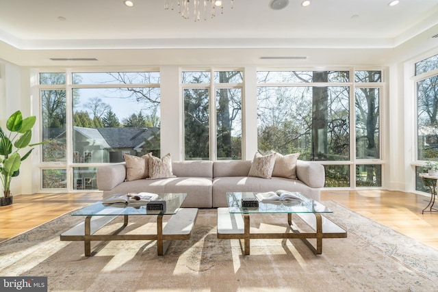 sunroom with visible vents, a tray ceiling, recessed lighting, and wood finished floors