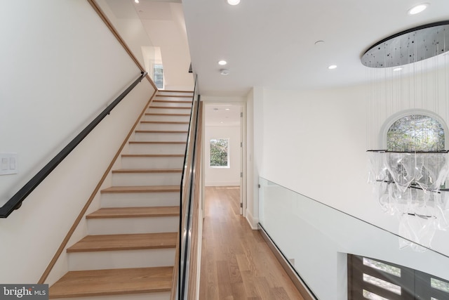 staircase with recessed lighting and wood finished floors