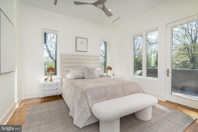 bedroom featuring access to outside, multiple windows, visible vents, and wood finished floors