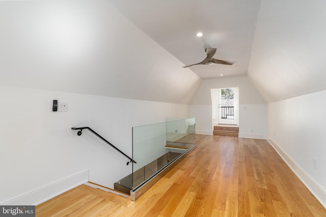 additional living space featuring lofted ceiling, baseboards, a ceiling fan, and wood finished floors