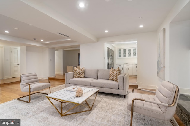 living area with visible vents, baseboards, light wood-type flooring, and recessed lighting