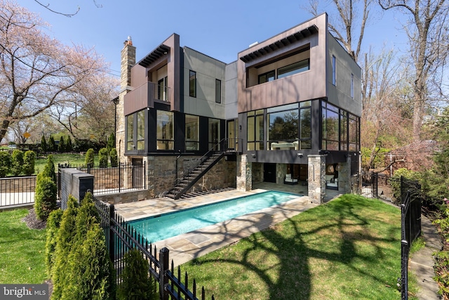 rear view of house featuring a fenced in pool, a patio, stairs, fence, and a lawn