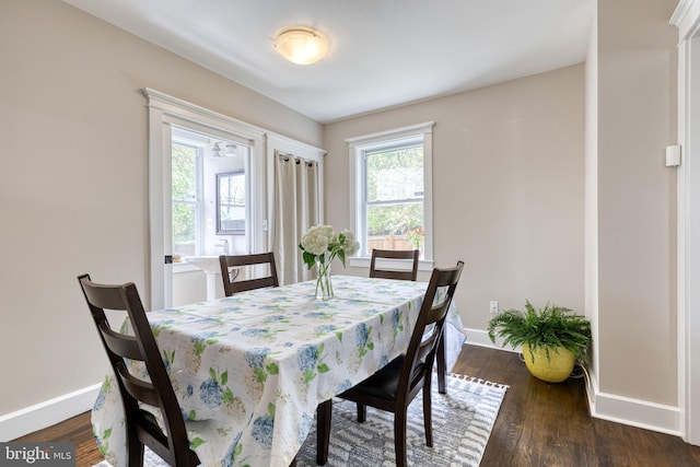 dining space with baseboards and dark wood finished floors