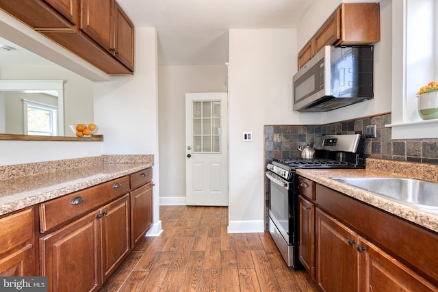 kitchen with light countertops, baseboards, dark wood-type flooring, and appliances with stainless steel finishes