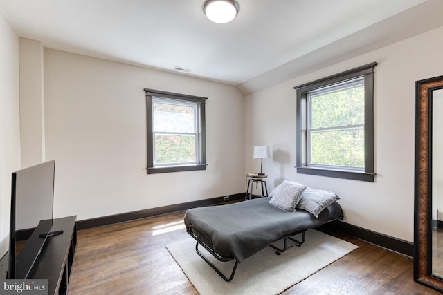 living area featuring plenty of natural light, wood finished floors, visible vents, and baseboards