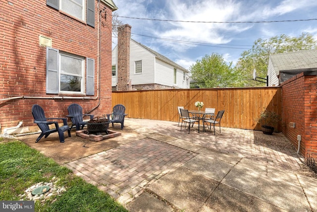 view of patio featuring a fenced backyard, a fire pit, and outdoor dining area