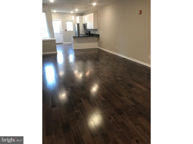 1315 N 6th St, Philadelphia, PA 19122 - unfurnished living room with dark wood-type flooring and baseboards