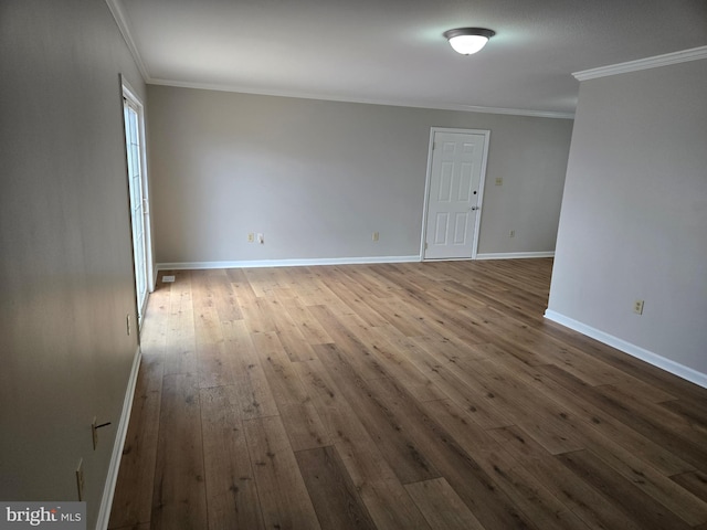 empty room featuring baseboards, hardwood / wood-style floors, and ornamental molding