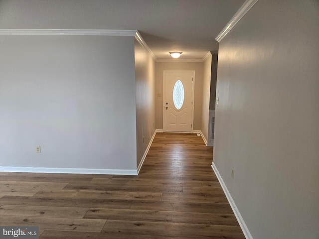 entryway with dark wood-type flooring, ornamental molding, and baseboards