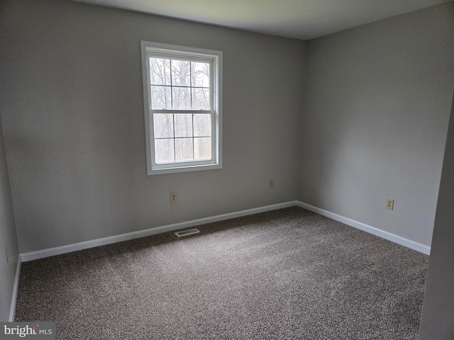 empty room with visible vents, baseboards, and carpet floors