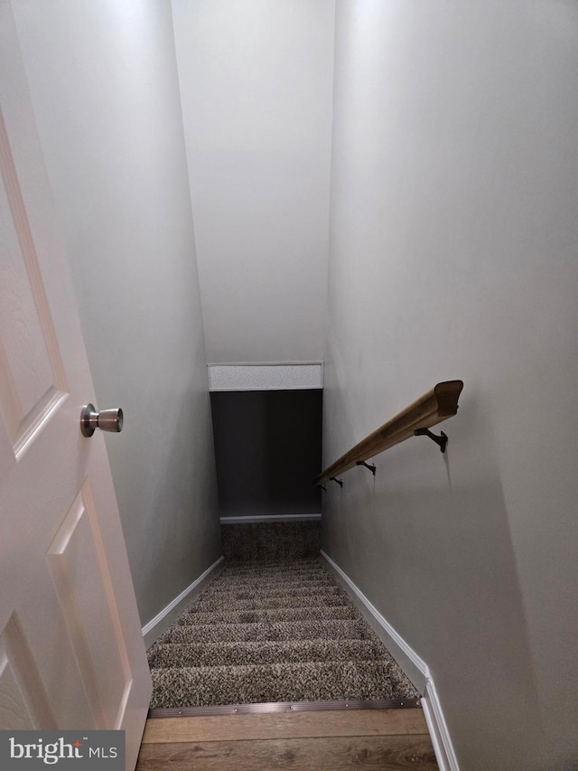 staircase with baseboards and wood finished floors