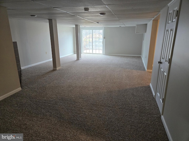 below grade area with carpet floors, baseboards, and a paneled ceiling