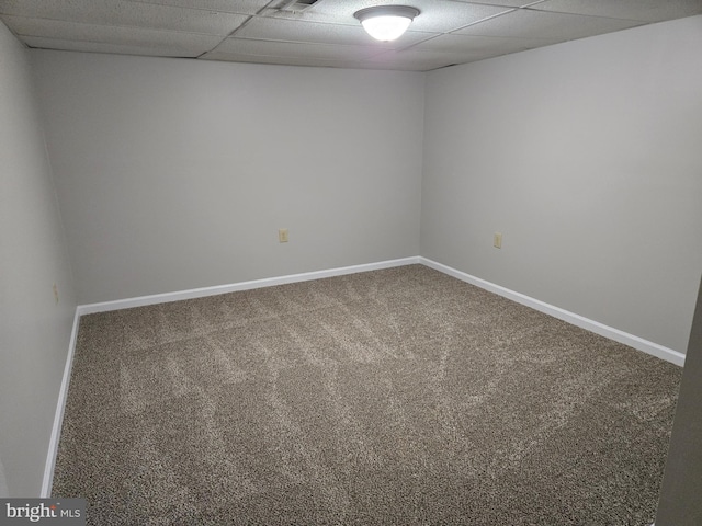 carpeted spare room with a paneled ceiling and baseboards