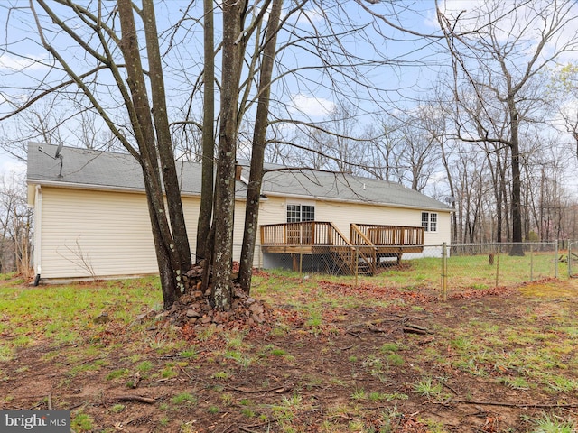 back of property featuring a wooden deck and fence