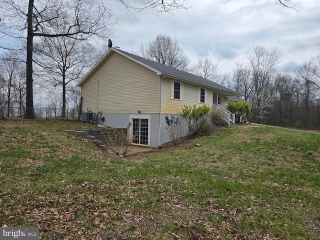 view of side of home featuring central air condition unit and a lawn
