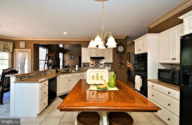kitchen with ornamental molding, a chandelier, a peninsula, under cabinet range hood, and black appliances