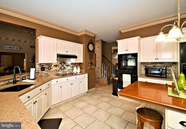 kitchen with a sink, under cabinet range hood, crown molding, black appliances, and decorative backsplash