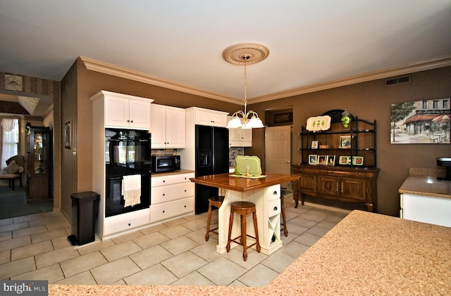 kitchen with visible vents, white cabinets, a chandelier, black appliances, and butcher block countertops
