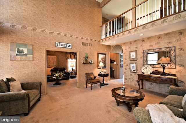living room with visible vents, arched walkways, and carpet