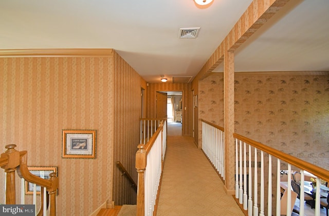 hall featuring visible vents, an upstairs landing, carpet floors, and wallpapered walls