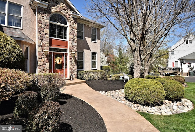 exterior space featuring stucco siding and stone siding