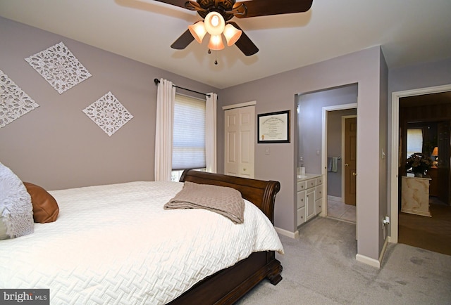 bedroom featuring a closet, baseboards, light colored carpet, and a ceiling fan