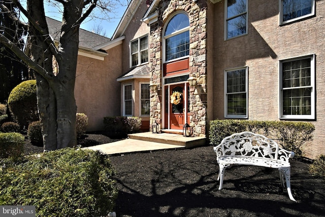 entrance to property with stucco siding and stone siding