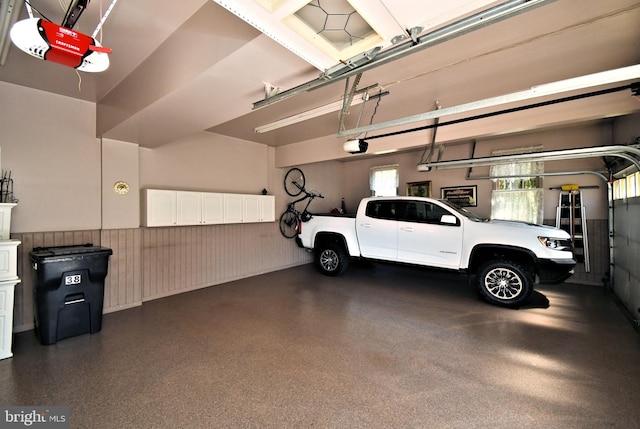 garage with a garage door opener and a wainscoted wall