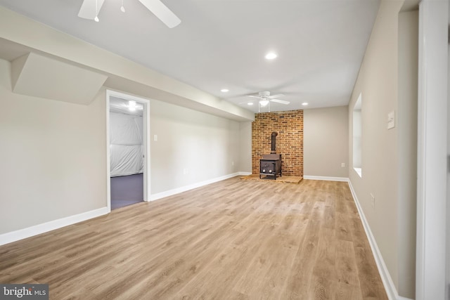 804 Farms River Rd, Front Royal, VA 22630 - unfurnished living room with ceiling fan, a wood stove, light wood-style floors, recessed lighting, and baseboards