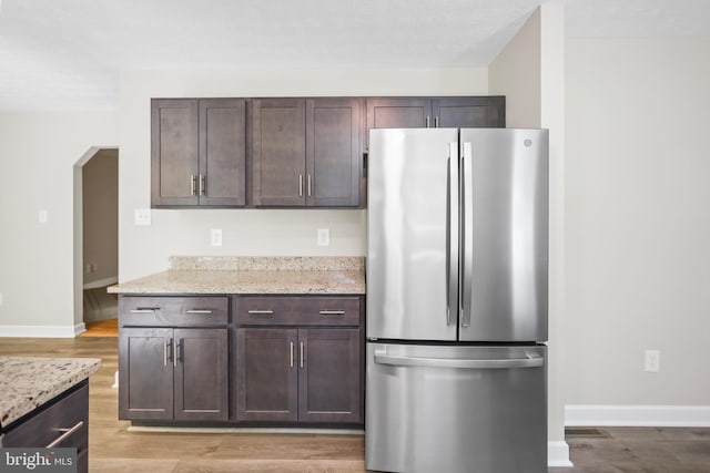 804 Farms River Rd, Front Royal, VA 22630 - kitchen with freestanding refrigerator, dark brown cabinets, light wood-style flooring, baseboards, and light stone countertops