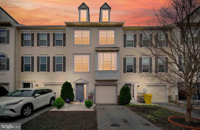 townhome / multi-family property with driveway and a garage
