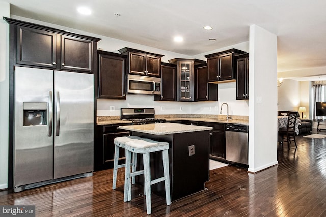 kitchen with dark wood-style flooring, recessed lighting, a center island, stainless steel appliances, and a sink