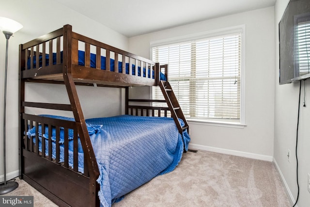 carpeted bedroom featuring baseboards and multiple windows