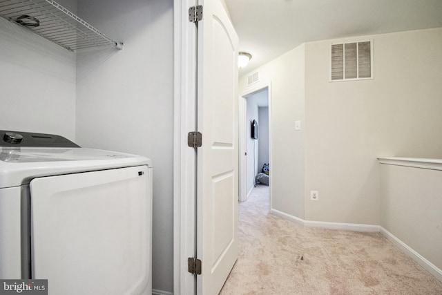 laundry area with visible vents, light colored carpet, and baseboards