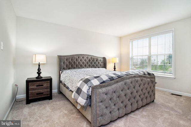 carpeted bedroom featuring visible vents and baseboards