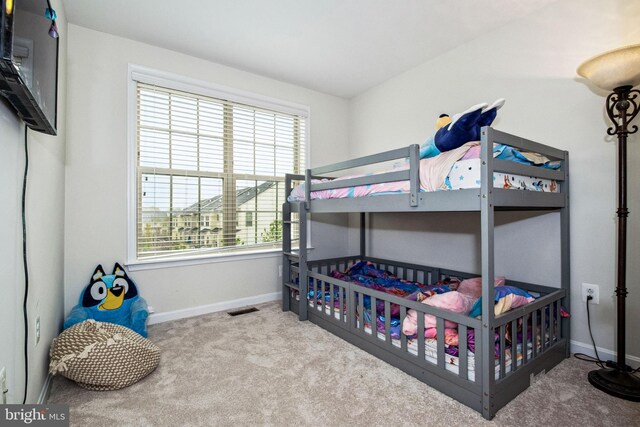 carpeted bedroom with visible vents and baseboards