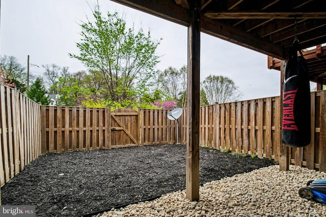 view of yard with a fenced backyard and a gate