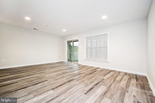 empty room featuring recessed lighting, light wood finished floors, visible vents, and baseboards