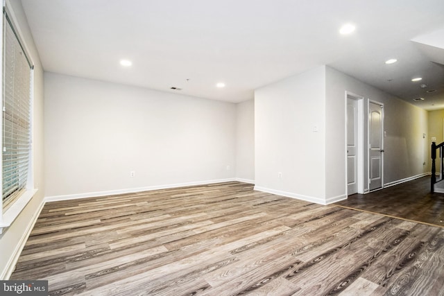 empty room with visible vents, baseboards, recessed lighting, and wood finished floors
