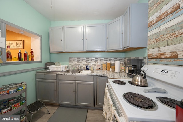 4990 W Thompson St, Philadelphia, PA 19131 - kitchen featuring gray cabinets, light countertops, backsplash, white electric range oven, and a sink