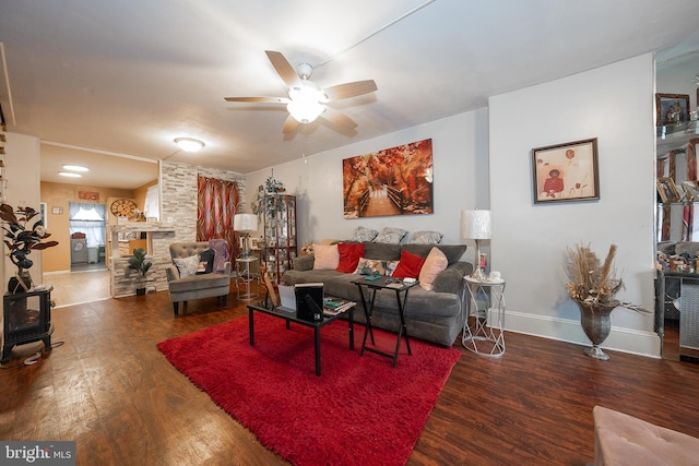 4990 W Thompson St, Philadelphia, PA 19131 - living area featuring a wood stove, ceiling fan, baseboards, and wood finished floors
